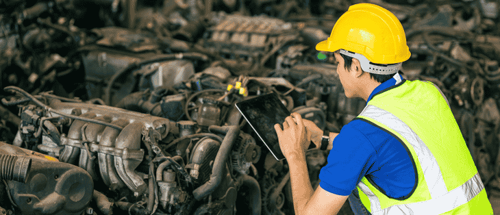 Técnico que trabaja en un desguace de automóviles.